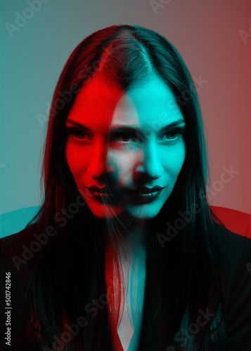 Woman with long dark hair close-up fashion portrait in RGB color split. RGB effect make reflection of model face in red and blue colors. Abstract and futuristic looking style