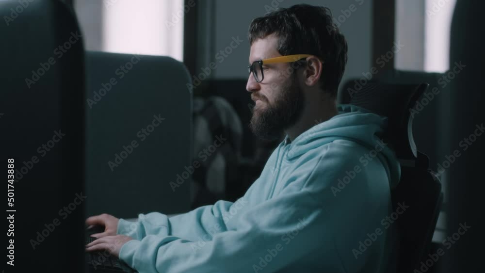 Web developer in glasses working on a computer in IT office during the war and starting to run after an explosion Web developer in glasses working on a computer in IT office during the war and starting to run after an explosion