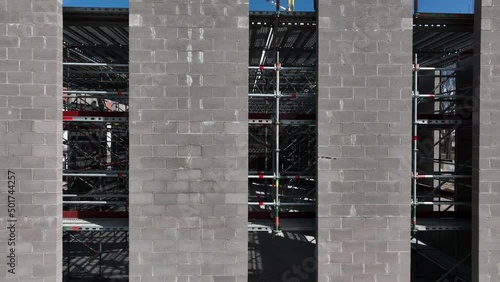 Close-up shot of the building under construction, camera is moving along the concrete wall. photo