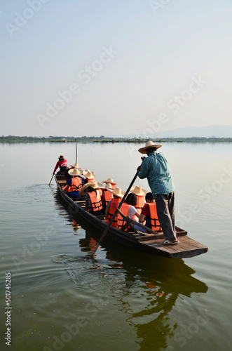 Guide local people paddle wooden boat bring thai and foreign travelers trip tour for travel visit respect praying Luang Por Sila buddha statue at Kwan Phayao lake swamp freshwater in Phayao, Thailand