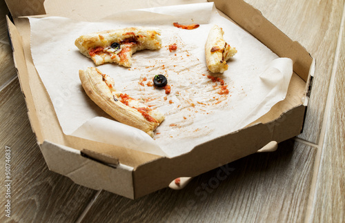 empty cardboard pizza box with pizza leftovers. After meal. Dirty dishes after dinner.