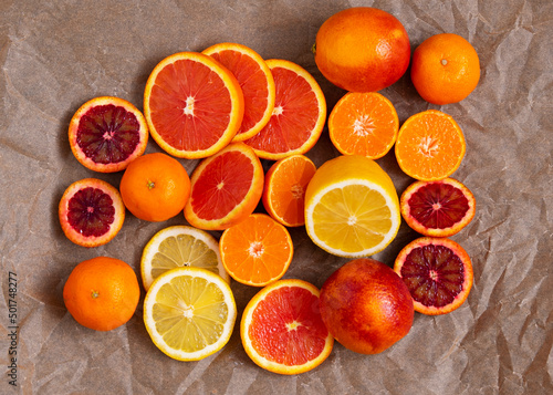 pieces of citrus fruits: orange, blood orange, lemon, tangerine on a background of crumpled craft paper. selective focus © Лариса Снимушкина