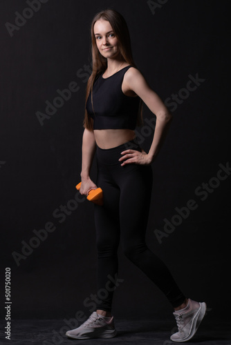 Beautiful black dumbbells . Maiden orange a on background with orange two gym, for shape body for fit and dumbbell care, aerobics plus. Active beginner joy, arms young overweight doing