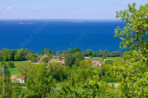 View over a rural lush landscape and the blue lake Vättern in Sweden.