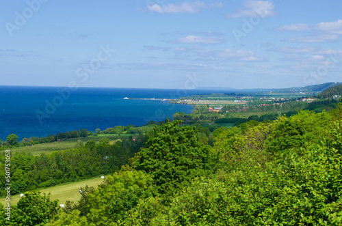 View over a rural lush landscape and the blue lake Vättern in Sweden. © AnnLouise