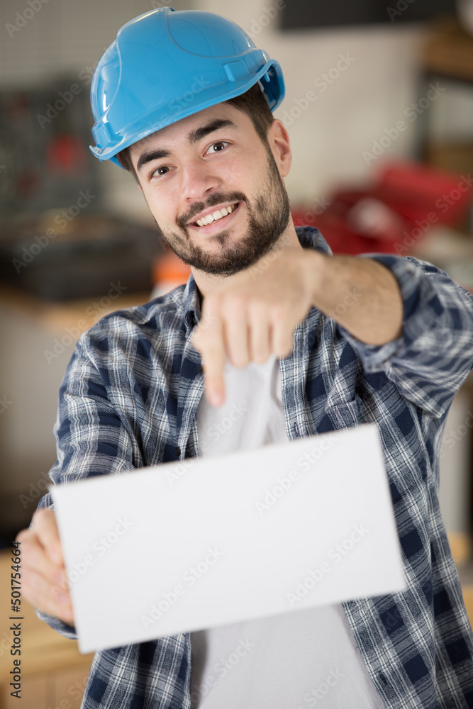 worker wearing hard hat and holding empty banner worker wearing hard hat and holding empty banner