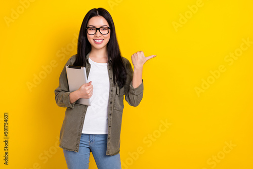 Photo of cheerful charming female advertise product shopping season bargains isolated on yellow color background