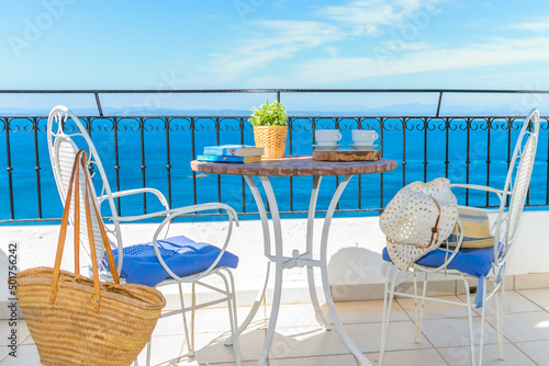 white wrought iron table and chairs on a terrace with beautiful views of the sea to enjoy your vacation.