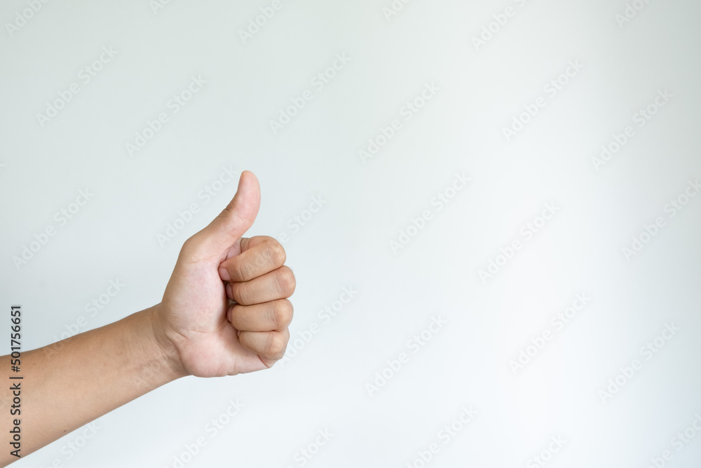Closeup of asian male left hand showing thumbs up sign on white background