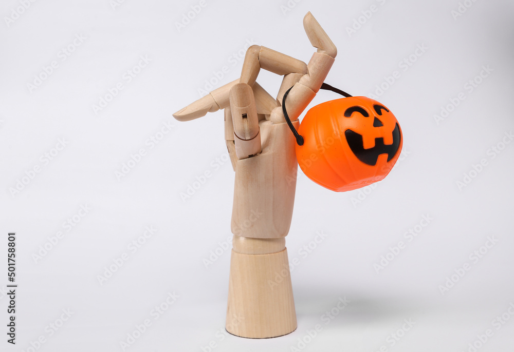 Wooden hand with halloween jack pumpkin bucket isolated on white background. Trick or Treat Wooden hand with halloween jack pumpkin bucket isolated on white background. Trick or Treat