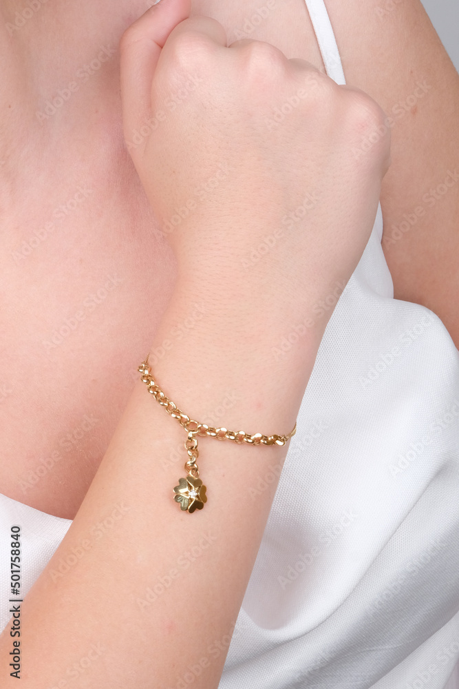 women's gold bracelet on girl's hand, women's accessories, jewelry, gold  bracelet with stones, women's jewelry, girl bracelet on her arm, gold  bracelet with stones Stock Photo