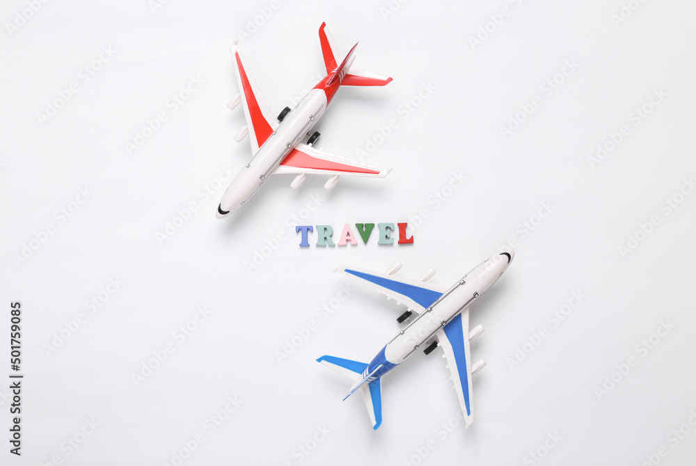 Travel concept. Model passenger air planes with text travel on white background. Top view. Flat lay Travel concept. Model passenger air planes with text travel on white background. Top view. Flat lay