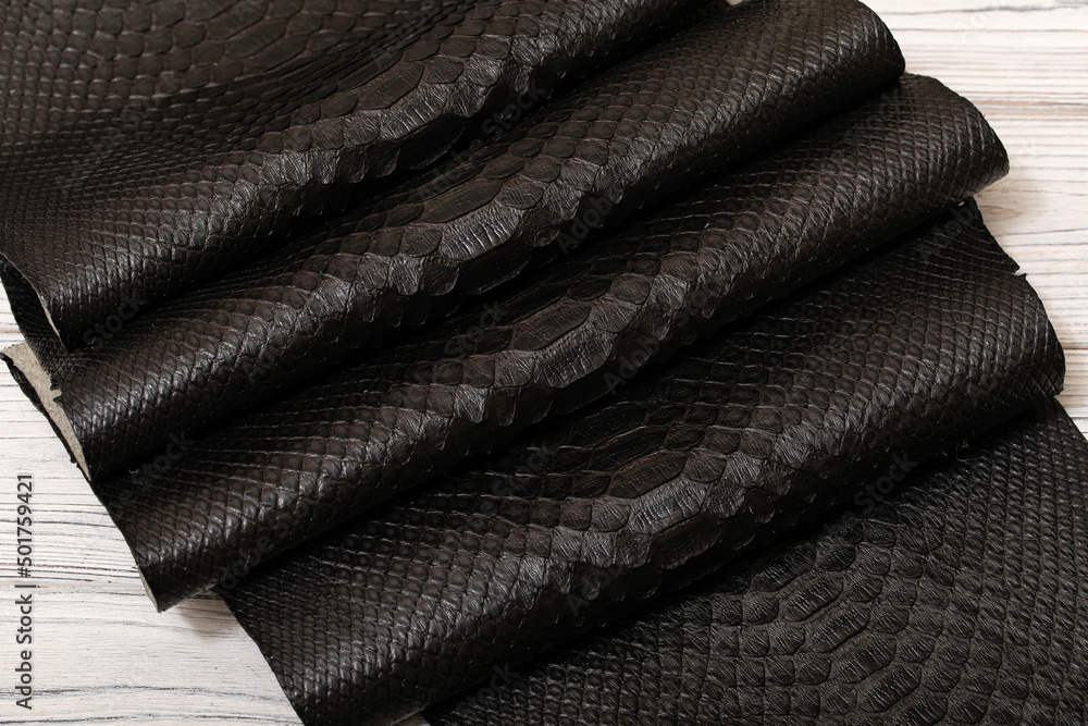 dark brown dyed genuine natural python leather on the wooden table dark brown dyed genuine natural python leather on the wooden table