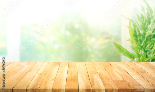 Obraz na plátně Empty wood table top on blur abstract green garden from window kitchen in the morning