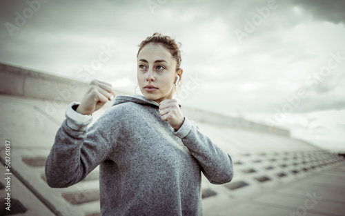 Canvas-taulu Sporty woman fighter stands in a fighting stance outdoors
