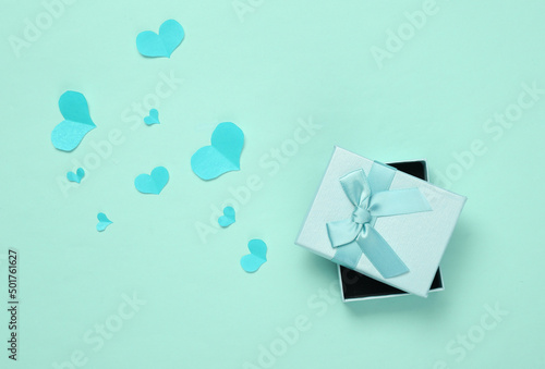 Gift box with Paper Cut hearts on blue background. Valentines day concept. Top view