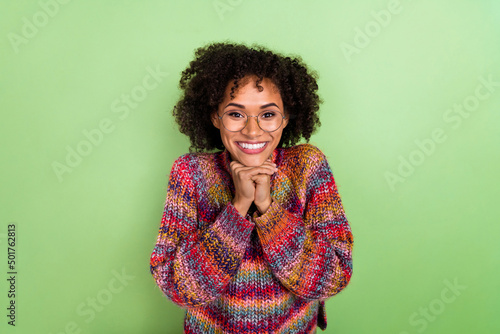 Portrait of excited positive lady hands under chin beaming smile isolated on green color background