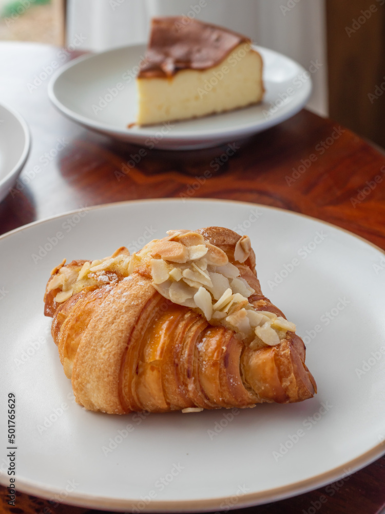 Almond Croissant on the white round plate. Almond Croissant on the white round plate.
