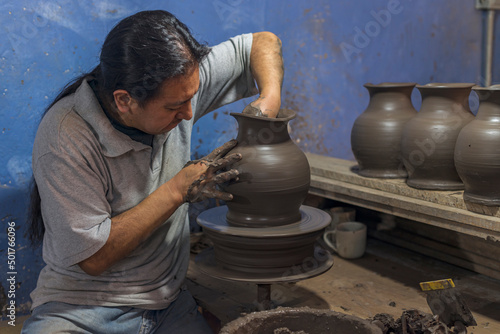 Canvas-taulu Mexican artisan creating a vase of clay for the talavera process