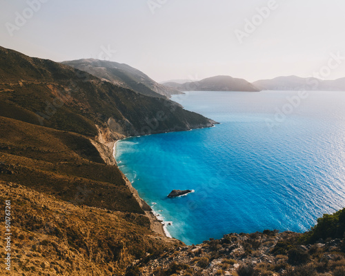 Kefalonian coast cliffs against hazy sky azure water of the Ionian Sea photo