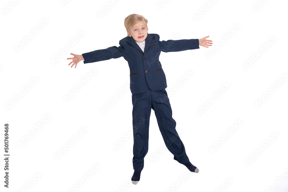 Eight-year-old boy in school uniform spread his arms to the sides. Scared face. Full-length portrait of schoolboy in isolation on white background.