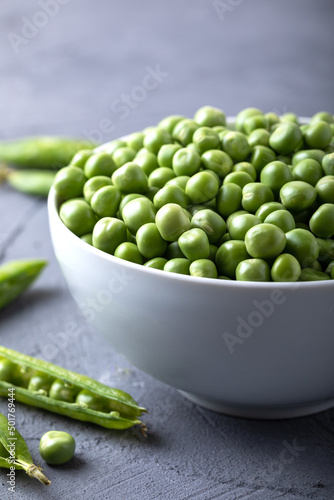 Green peas in white bowl with fresh pods. Fresh sweet pea pods.