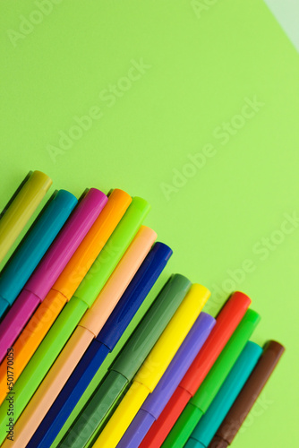 Multi-colored stationery felt-tip pens on a background of multi-colored cardboard paper.