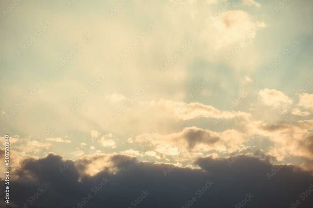 Dramatic sunset sky. The rays of the sun at sunset. Cloudy sky with sun rays.