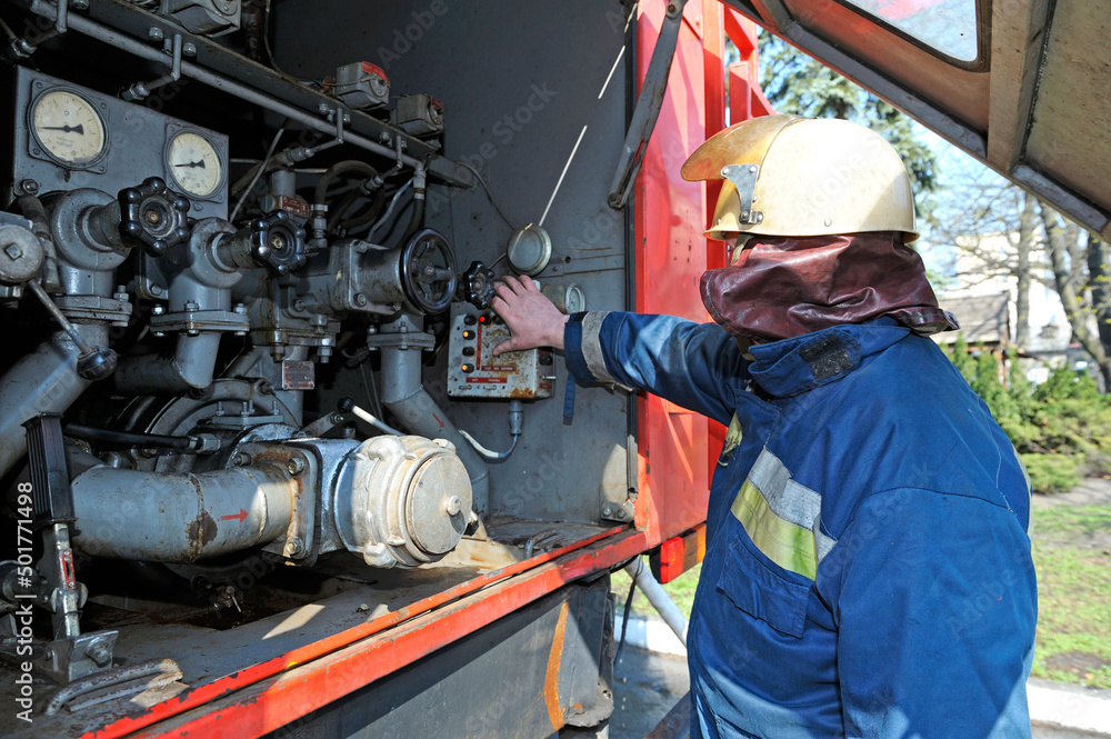 Fireman switching the water pump engine on control panel Fireman switching the water pump engine on control panel
