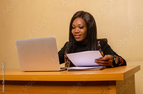 african lady in the office going through the document on her hand