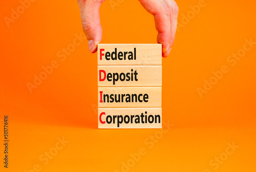 FDIC federal deposit insurance corporation symbol. Concept words FDIC federal deposit insurance corporation on blocks on orange background. Business FDIC federal deposit insurance corporation concept. photo