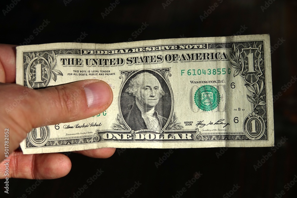 one dollar bill: an unrecognizable man's hand displays an isolated