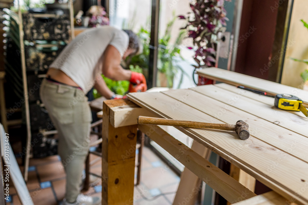 Man building a handmade wooden table with pine boards Man building a handmade wooden table with pine boards