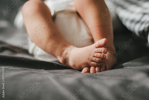 Close up of newborn feet. Soft focus. Grey and white colors.