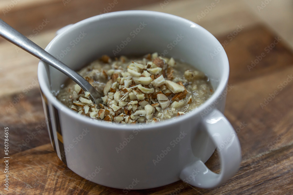 Porridge with walnut topping in a bowl. Appetizing and healthy breakfast. Close-up. Porridge with walnut topping in a bowl. Appetizing and healthy breakfast. Close-up.