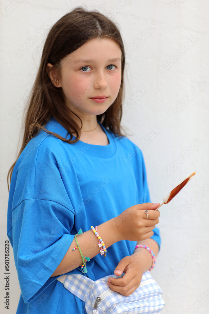 teen girl with lollipop is having fun. happy cool Kid in blue t-shirt with bright candy. teen girl with lollipop is having fun. happy cool Kid in blue t-shirt with bright candy.