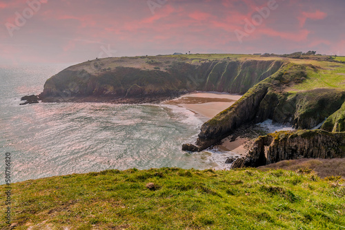 A view over Skrinkle Bay at sunset from the coastal path in Pembrokeshire, South Wales in springtime photo