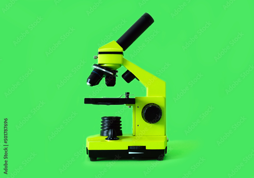 Microscope on a bright green background. High quality photo. Microscope on a bright green background. High quality photo.