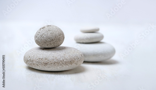 grey pebble stones close up on abstract blurred light background. spa  relax  meditation concept. spiritual practice for harmony  life balance. minimal composition