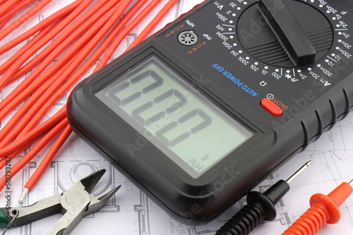 Multimeter and tools for electrical installation in a close-up schematic diagram.