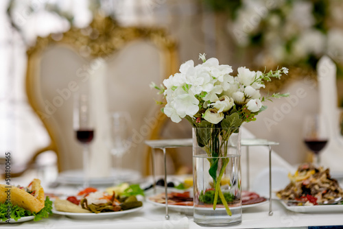 Obraz na płótnie Classic and elegant artificial white decorative roses in glass full of water on wedding presidium w salonie