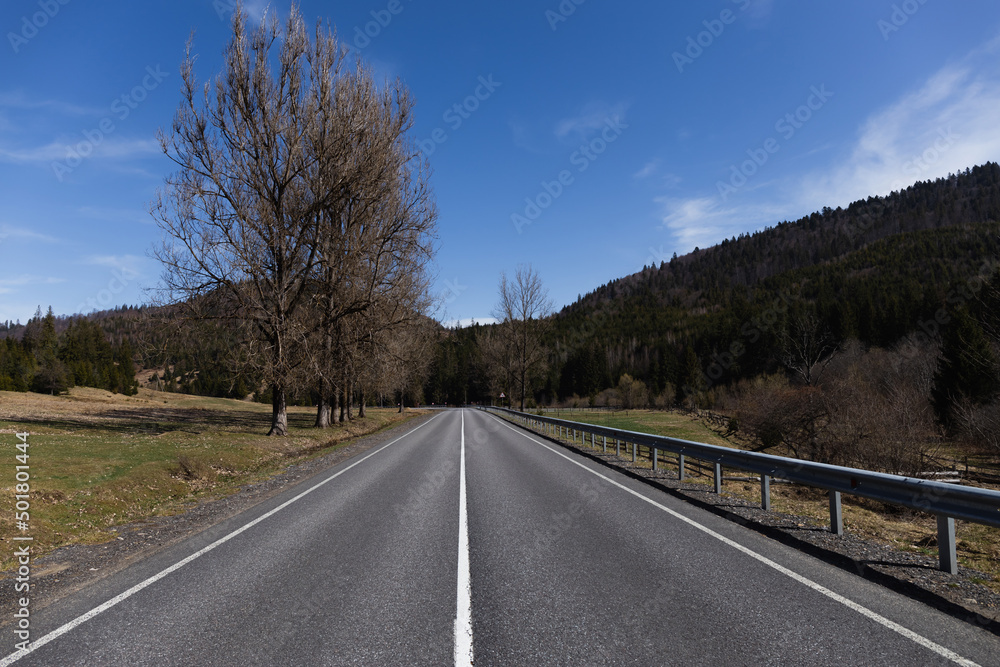 Empty road, mountains and sky at background.