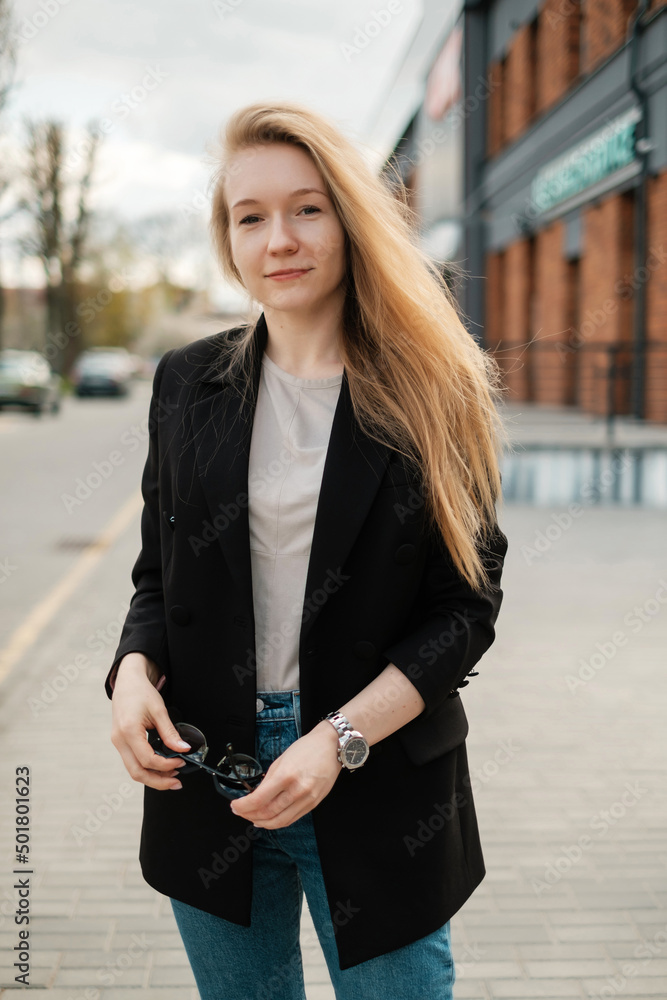 Woman in a black jacket with sunglasses on the street Woman in a black jacket with sunglasses on the street