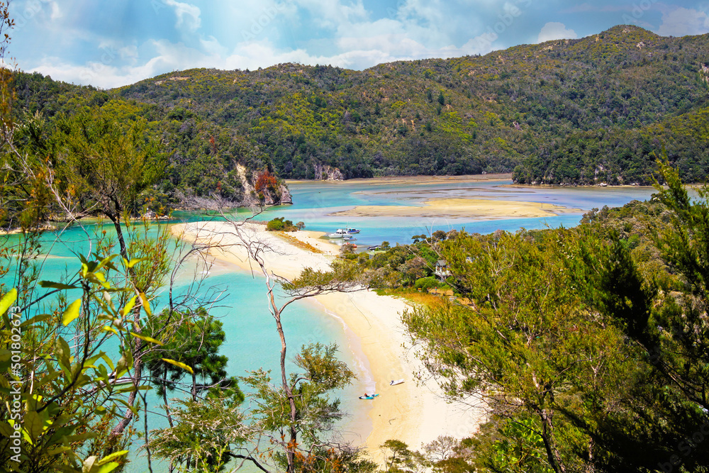 Beautiful scenic landscape with blue lagoon, sandbanks beach, green hills and blue sky - Abel Tasman NP, New Zealand
