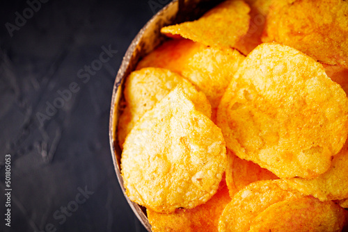 golden crispy potato chips on a dark background