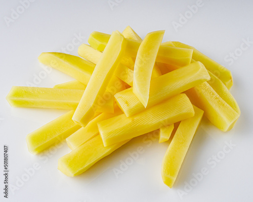 peeled potatoes sliced for french fries on a white background