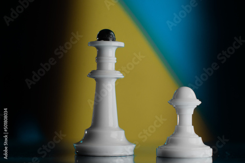 Chess pieces against the background of the ensign of Ukraine. Concept