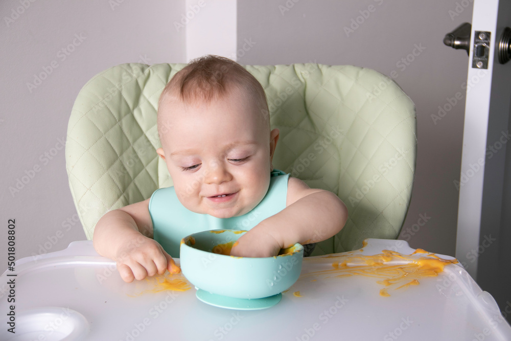 a little boy touches spaghetti with his hands while sitting in a child's chair a little boy touches spaghetti with his hands while sitting in a child's chair