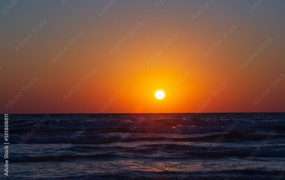 Beautiful sunset in the Mediterranean sea seen from Haifa beach promenade in Israel. Haifa beach sunset. The picture was captured a few minutes before the sun completely set. Background ,copy space