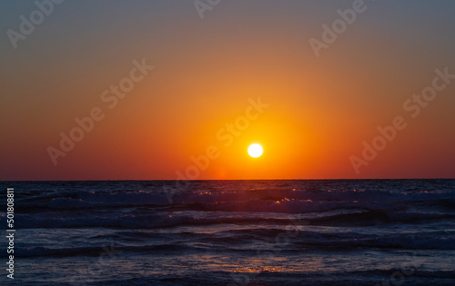 Beautiful sunset in the Mediterranean sea seen from Haifa beach promenade in Israel. Haifa beach sunset. The picture was captured a few minutes before the sun completely set. Background  copy space